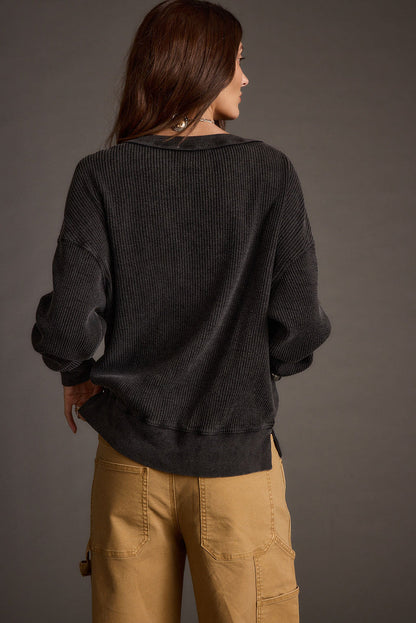 Back view of the black knit top showing the silhouette and fit.