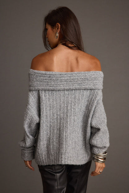 Back view of heather grey off-the-shoulder ribbed sweater with folded neckline and silver bangles.