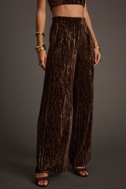 Back view of the espresso velvet trousers showing the silhouette and fit.