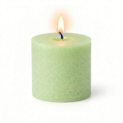 A lit green votive candle on white background