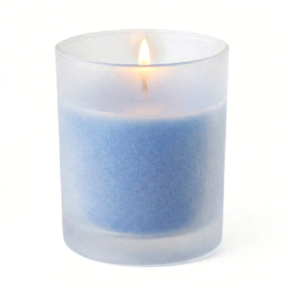 A lit blue candle inside one of the Frosted Votive Holders on white background