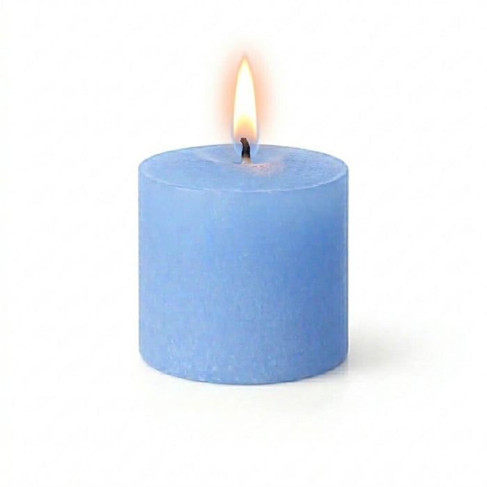 A lit blue candle styled with Frosted Votive Holders on a white background