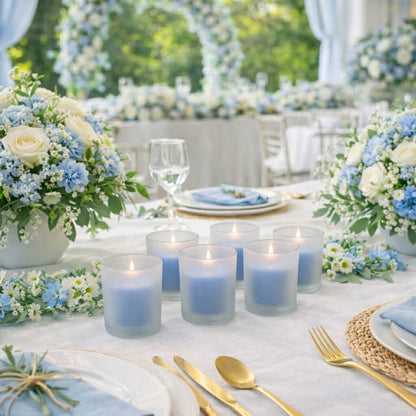 Six blue candles in Frosted Votive Holders on a wedding table setup with flowers