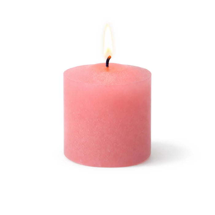 Lit pink votive candle isolated on a white background
