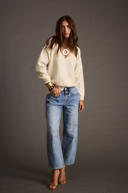 Back view of the ivory sweater showing the silhouette and fit.