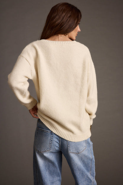 Full-length view of the ivory sweater showing the drape and movement.