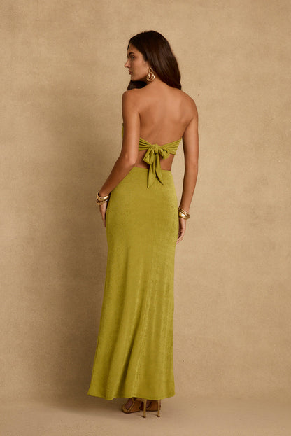 Back view of chartreuse strapless maxi dress with open tie-back detail and gold bangles.