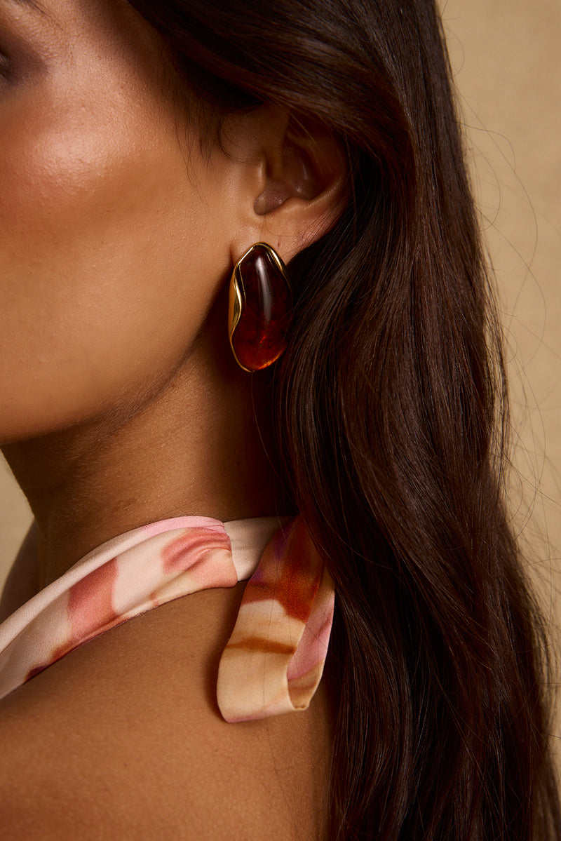 Model wearing the 12th Tribe Veda Amber Stone Earrings with warm amber tones. Featuring a natural stone drop style. Pair with elevated looks for weddings, bachelorette parties, and vacation outings.