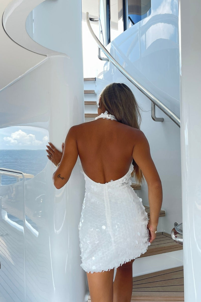 Back view of the white mini dress showing the silhouette and fit.