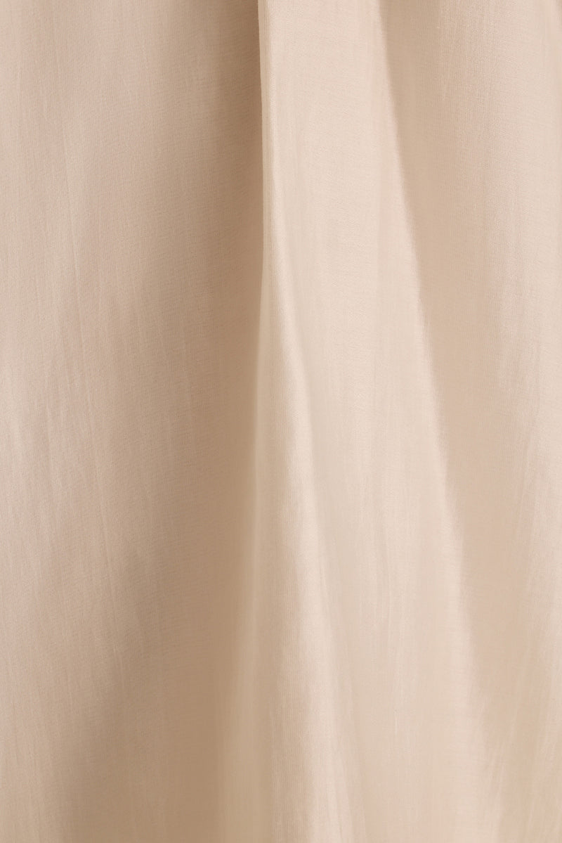Close-up of the Zella halter top's ivory fabric draping in soft vertical folds.
