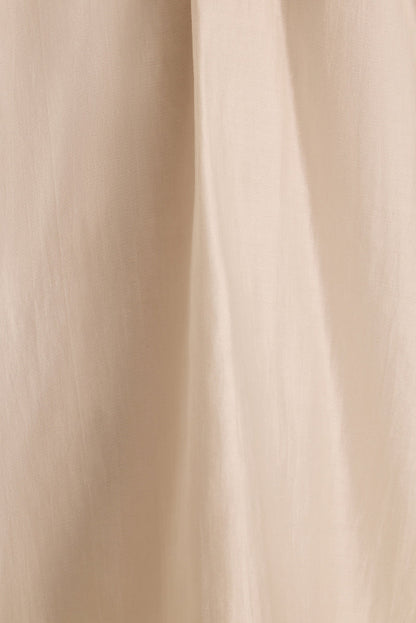 Close-up of the Zella halter top's ivory fabric draping in soft vertical folds.